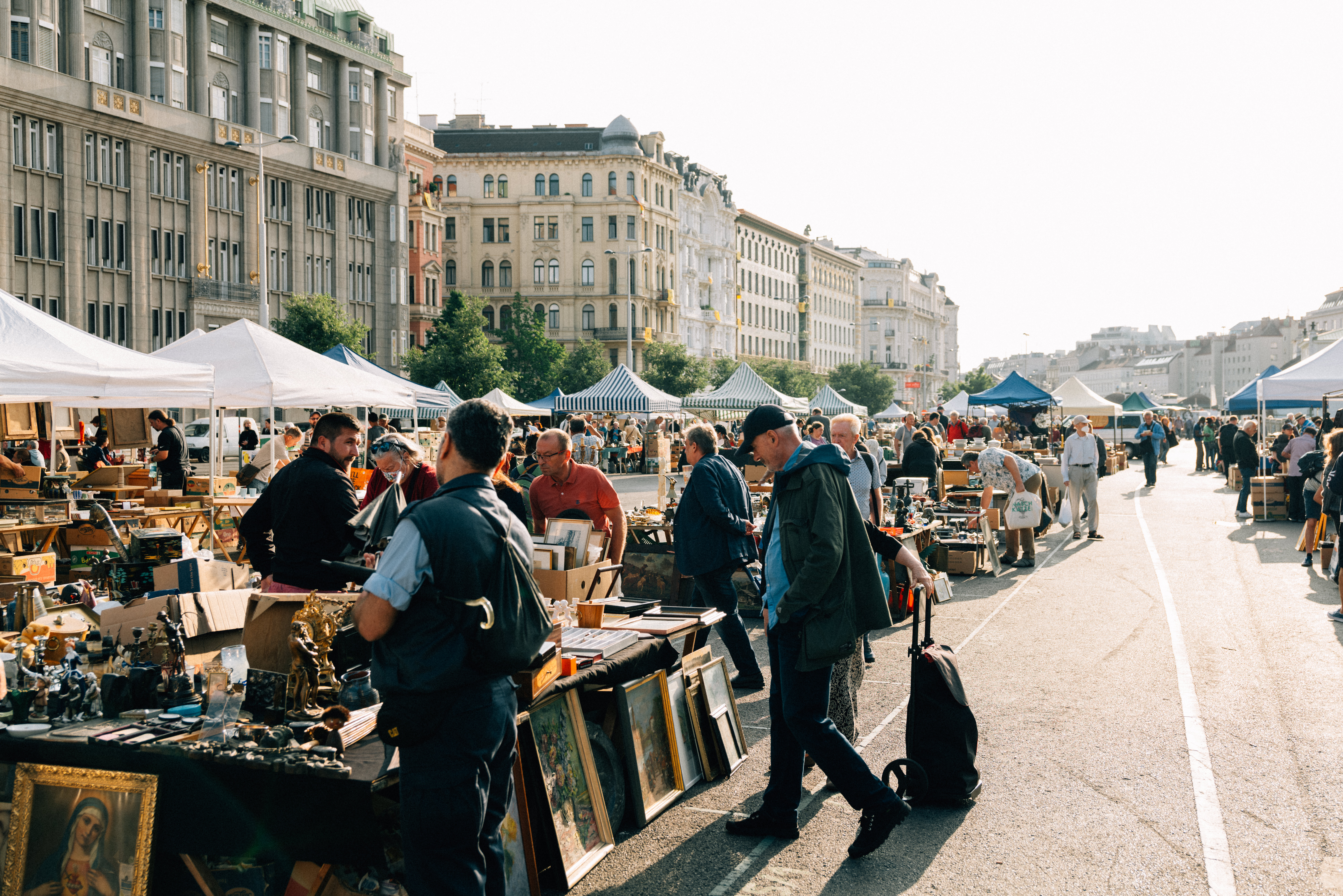Flea market at the Naschmarkt: People standing at the various stands and examining the goods on offer