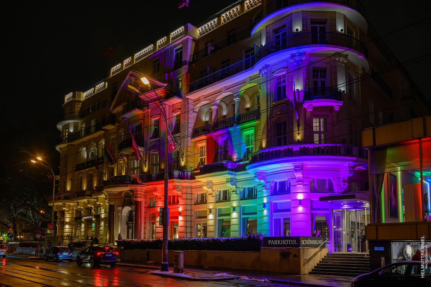 Foto des Parkhotels Schönbrunn bei Nacht in der Beleuchtung des Regenbogens anlässlich des Wiener Regenbogenballs